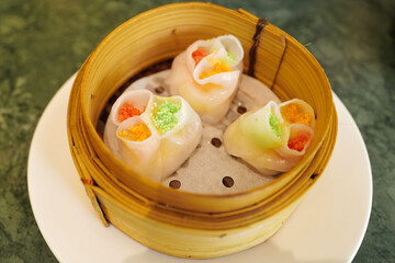 Chinese Dim Sum, steamed pork and seafood dumplings served in wooden basket container