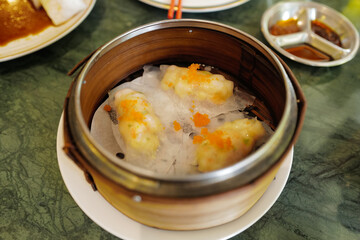 Chinese Dim Sum, steamed pork and seafood dumplings served in wooden basket container