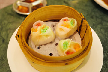 Chinese Dim Sum, steamed pork and seafood dumplings served in wooden basket container
