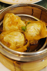 Close up Chinese Dim Sum, steamed pork and seafood dumplings served in wooden basket container