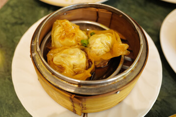 Close up Chinese Dim Sum, steamed pork and seafood dumplings served in wooden basket container