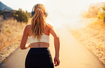 Woman running in the morning with earphones music motivation
