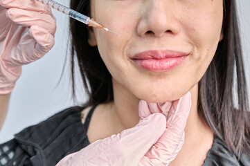아시아 한국의 주름진 한국여성 모델이 피부과 병원 또는 성형외과에서 주사기로 시술을 함