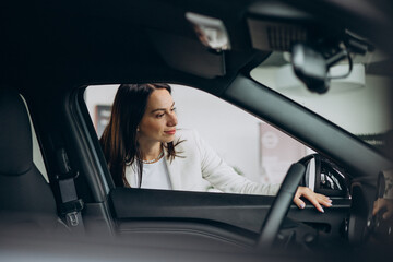 Obraz na płótnie Canvas Woman choosing new car in a car showroom