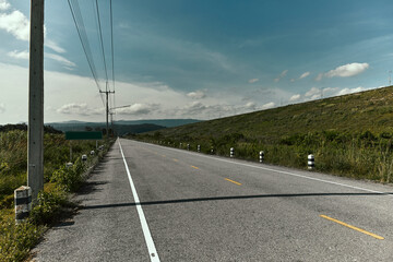 Highway in perspective with yellow line and blue sky.
