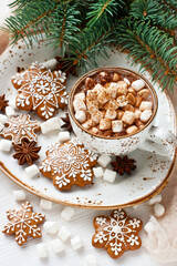 Mug filled with hot chocolate and marshmallows and gingerbread cookies