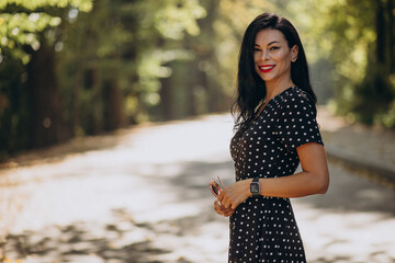 Young attractive woman in classy dress standing in forest