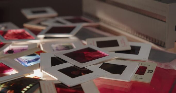 Slow camera movement over a pile of colour slides. Background shot