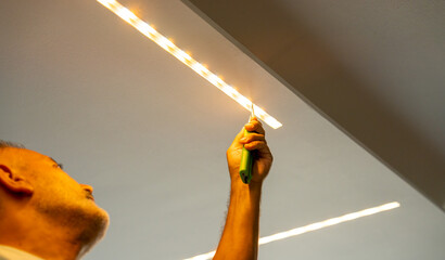 Led strip with yellow warm light, light installation. Male installer