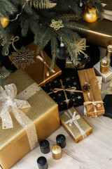 Home interior with decorated Christmas tree in black and gold colors and gifts under it, Merry Christmas and Happy New Year