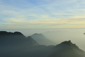 Photo illustration of a mountain landscape covered in milky white clouds