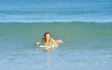 Pretty young woman surfer just before the takeoff of in the ocean waves