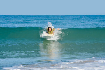 Pretty young woman surfer just before the takeoff of in the ocean waves