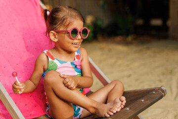 Funny cute girl on summer vacation. The child has fun on the beach. Cute baby girl in a colorful...