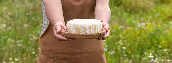 Dairy products on a cow farm are held by a woman in her hands. Selective focus.