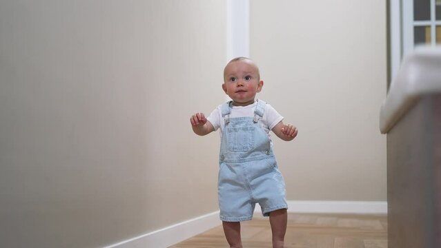 Baby's first steps. Toddler at home takes funny first steps. legs close-up. Baby's feet on floor at home. Kid's dream is to teaches to walk at home. Toddler learning to walk at home. walk baby teaches