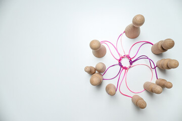 A round knot of threads unites wooden figures. Place for text