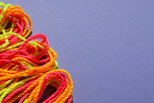 Close-up of green, orange and red braided shoelaces. Space for text