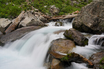 waterfall in the forest flowing through the river rocks, low shutter speed