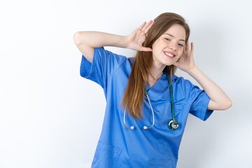 Young caucasian doctor woman wearing medical uniform Trying to hear both hands on ear gesture, curious for gossip. Hearing problem, deaf