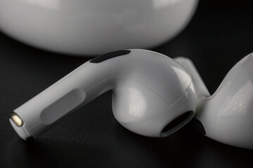 small white headphones on a black background