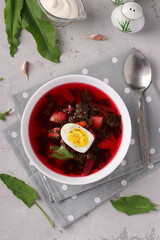 Beet soup with sorrel and egg in a white bowl, Closeup, View from above