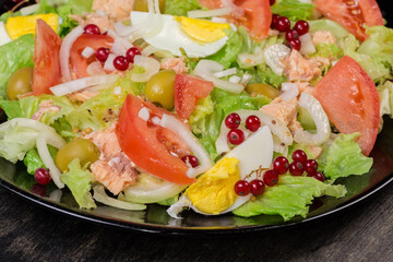 Lettuce salad with tuna, eggs and vegetables, fragment close-up