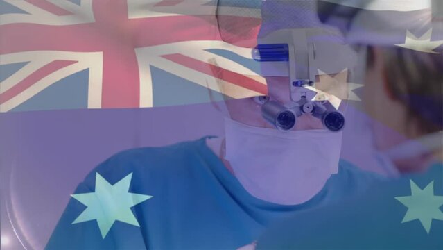 Animation of australian flag over caucasian doctor using magnifying glass and performing surgery