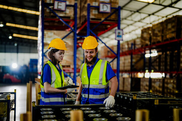 Obraz na płótnie Canvas checking and inspecting metal machine part items for shipping. male and woman worker checking the store factory. industry factory warehouse. The warehouse of spare part for machinery and vehicles.