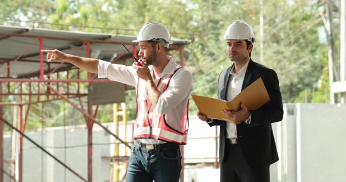building and construction worker, Hiapanic latin male wearing safety hard hat helmet standing at Prefabricated concrete walls Industry Manufacturing Factory. Unity and teamwork