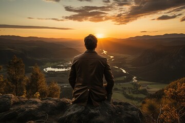 Man standing on a hill watching the sunset - stock photography concepts