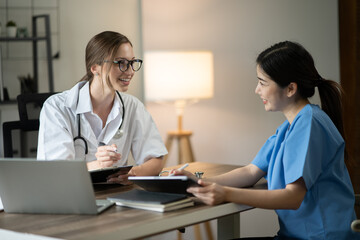 Fototapeta premium female doctor consulting with a female nurse at the clinic at the hospital