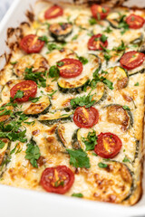 Delicious freshly prepared and baked meal with zucchini and cheese dressing. Rustic home made food concept.