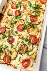 Delicious freshly prepared and baked meal with zucchini and cheese dressing. Rustic home made food concept.