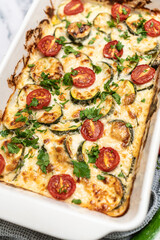 Delicious freshly prepared and baked meal with zucchini and cheese dressing. Rustic home made food concept.