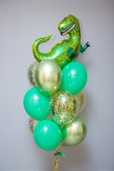green dinosaur balloon, bundle of green balloons and golden confetti balloons