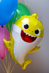 little yellow shark baby helium balloon on gray background