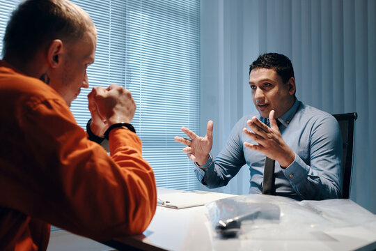 Policeman talking to crime in interrogation room