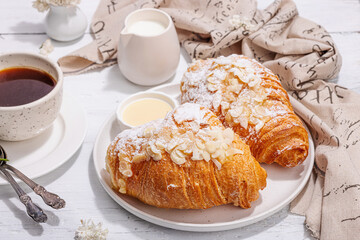 Good morning concept. Breakfast with cup of coffee and fresh croissant. Sweet creamy sauce