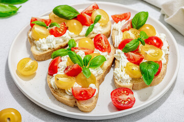 Fresh bread sandwiches with tomato cherry, cream cheese and basil leaves. Morning breakfast concept