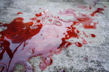 blood spills on the cement floor. concept photo illustration of murder and blood vomiting disease
