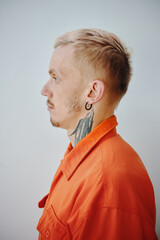 Profile portrait of criminal wearing orange jail uniform