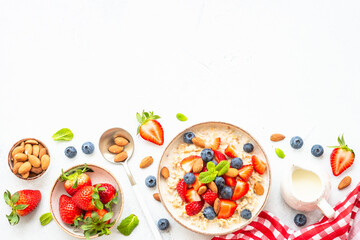 Oatmeal porrige with fresh berries and nuts. Healthy breakfast, top view.