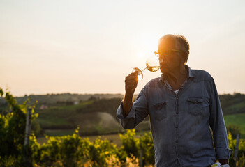 Wine producer man tasting the product after harvest and grape fermentation process - Vinification,...