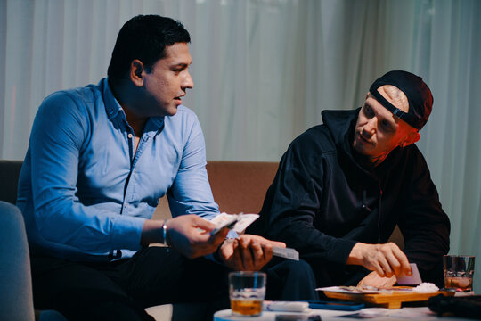 Drug cartel criminals counting money and snorting cocaine