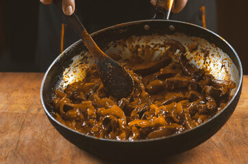 The cook prepares meat with vegetables and onion in a bowl . Oriental cuisine