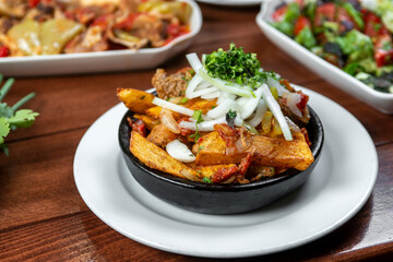 Beef stew with potatoes, carrots and herbs on black background with copy
