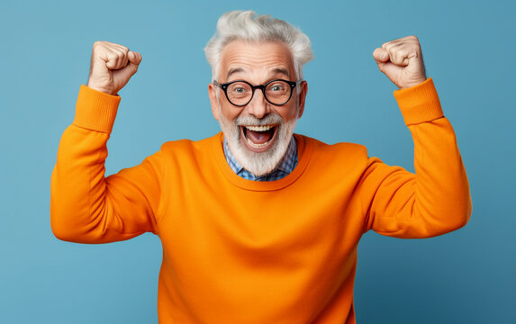 A elderly man exultation with his fists raised and a joyful expression - isolated on light blue background