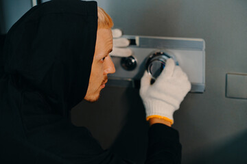 Burglar trying to open safe by listening for tumblers