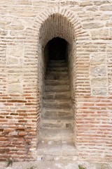 narrow entrance with stairs up to the castle